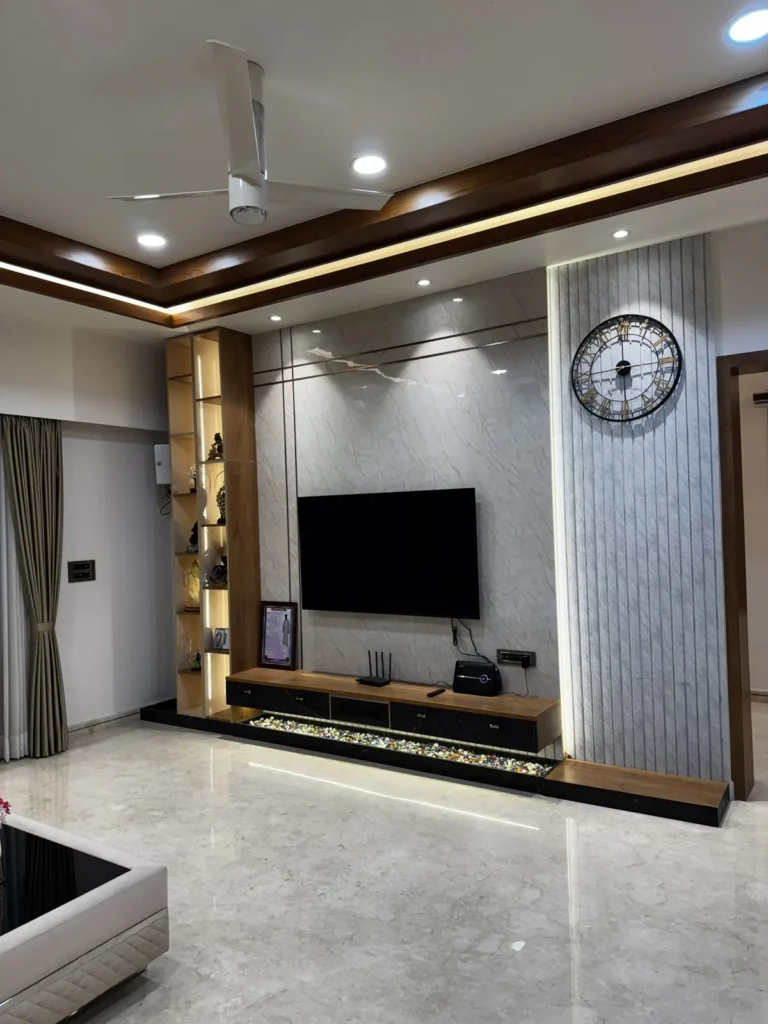 3 BHK living room in Gulbarga with fluted TV unit wall, wooden display shelves and cove-lit false ceiling by Aladi Interiors