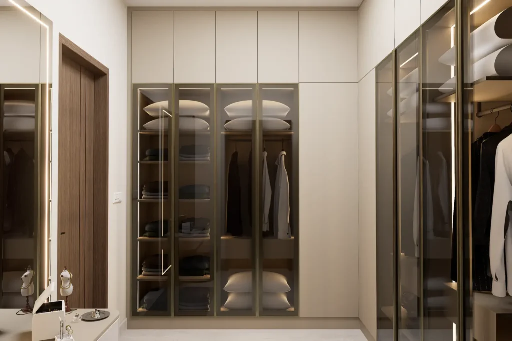 3D design of a Devanahalli 4 BHK walk-in wardrobe with tinted glass shutters, profile handles and internal lighting by Aladi Interiors
