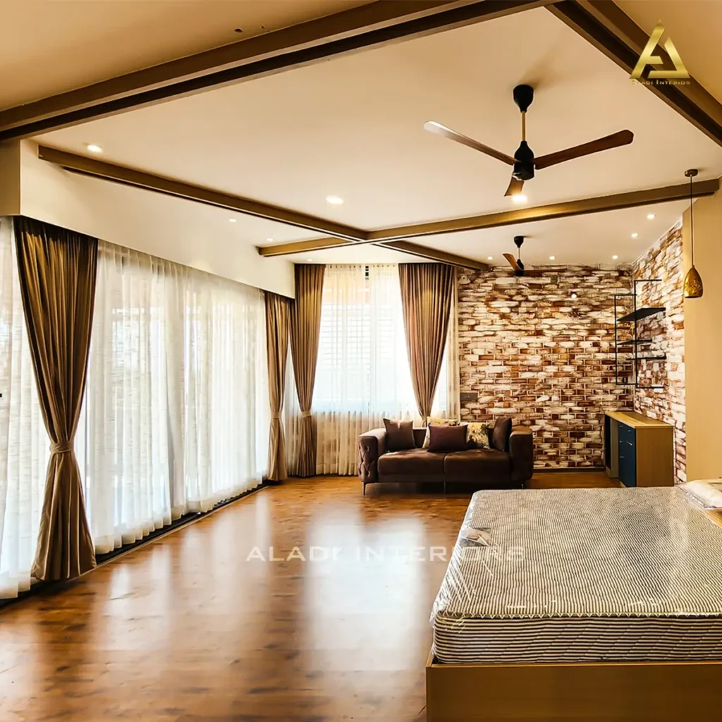Completed master bedroom lounge in a Gulbarga villa with exposed brick wall, wooden ceiling beams, wooden flooring and full-height curtains by Aladi Interiors