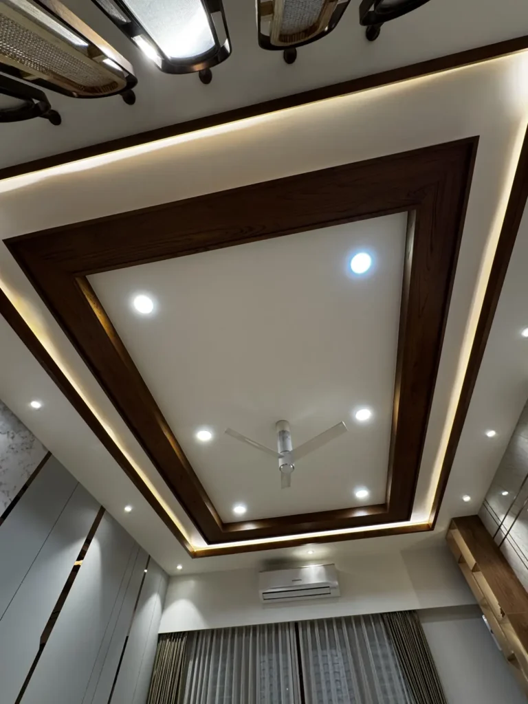Wooden frame false ceiling with cove LED lighting and spotlights in a 3 BHK home in Gulbarga by Aladi Interiors